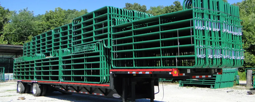 Green corral panels and gates loaded onto a flatbed trailer